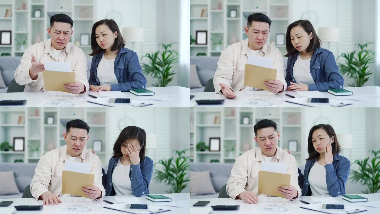 失望的亚洲夫妇坐在家里读坏消息的信