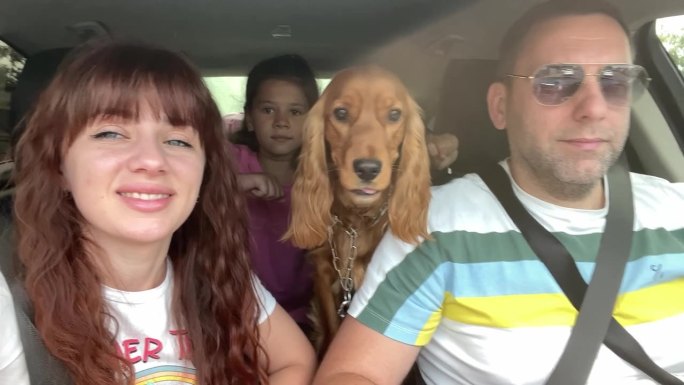 幸福的一家人带着他们的狗开车旅行。