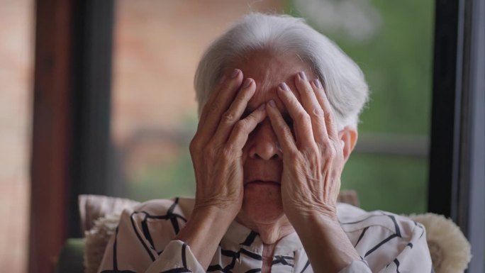 绝望的西班牙裔老年女性，双手捂脸，情绪紧张