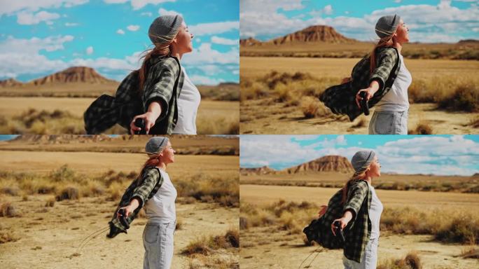 在摩洛哥的沙漠里，一名女子伸开双臂享受着阳光和风