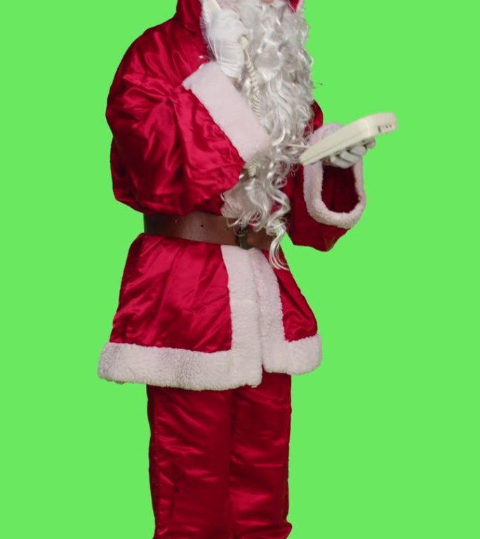 垂直视频圣诞老人的侧面视图使用固定电话