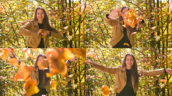 享受秋天的女人，把五彩缤纷的树叶扔向镜头
