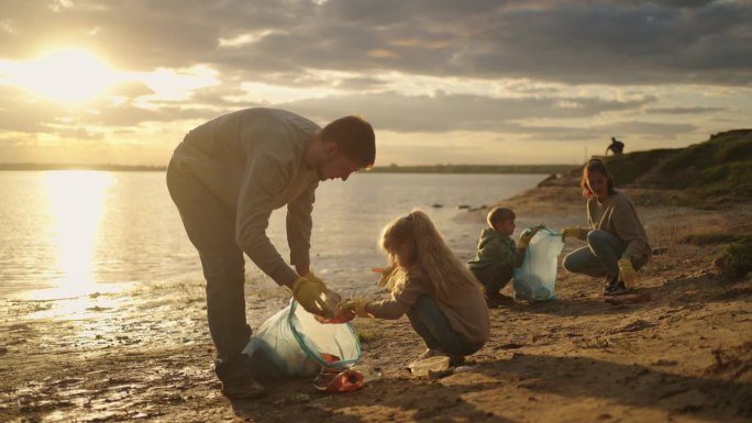 人们从河岸收集塑料垃圾的电影镜头，大人和孩子