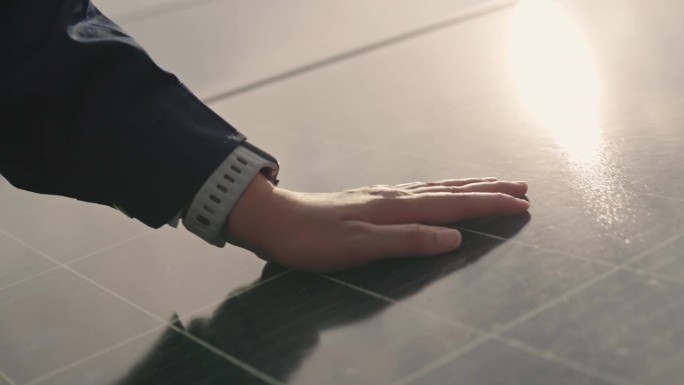 人的手放在太阳能板上，产生能量