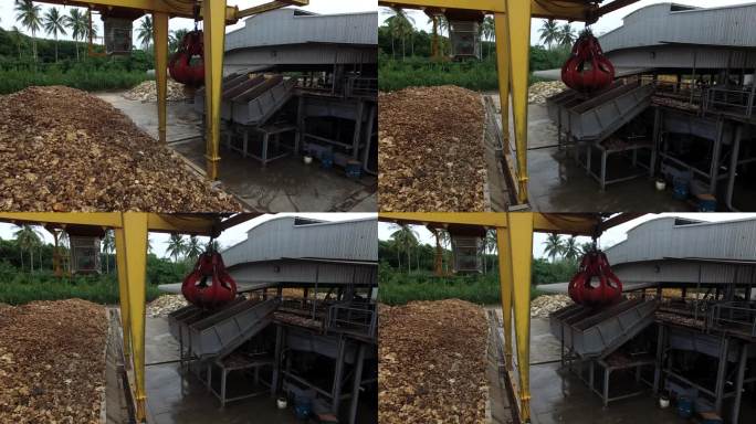 干燥后的天然生胶，用机械抓斗工业机在工厂室外区堆放在水泥地面上。