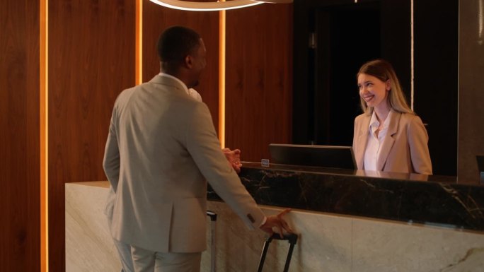 客人在酒店前台办理入住手续时，微笑着与接待员交谈