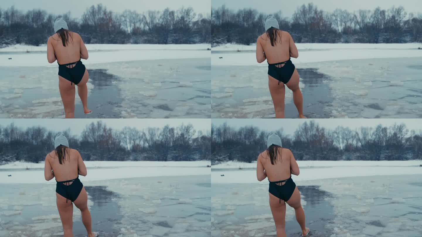 在寒冷的天气里冬泳的女人把脚浸在水里