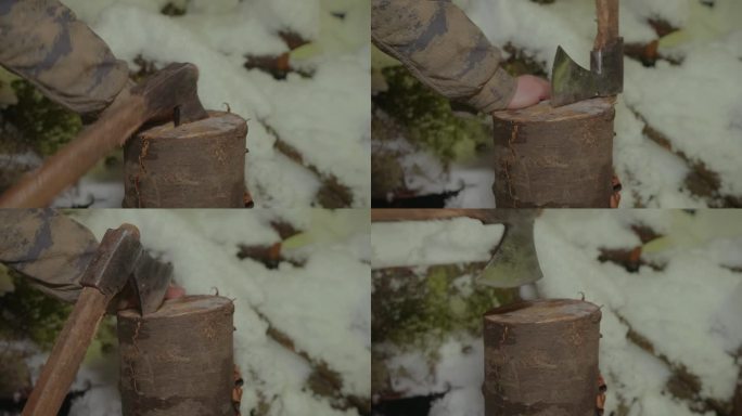 与寒冷作斗争，在下雪的条件下斧头劈柴的特写