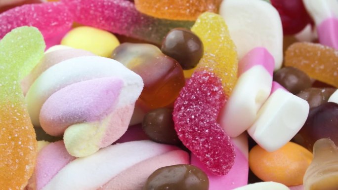 动感小熊软糖的4K彩色糖果特写，旋转可口的糖果旋转木马，甜食，不健康的加工垃圾食品，糖尿病风险因素和