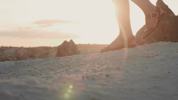 在卡帕多西亚的夕阳下，一个快乐的女人在悬崖上慢慢地走着。
