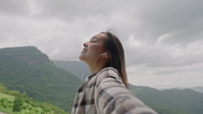 亚洲年轻女子张开双臂欣赏风景