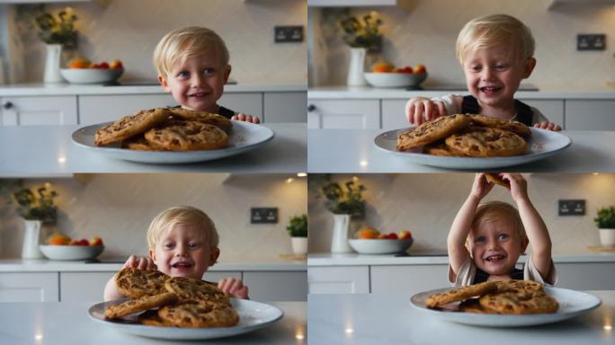 淘气的小男孩从家里厨房的盘子里拿了一块大饼干