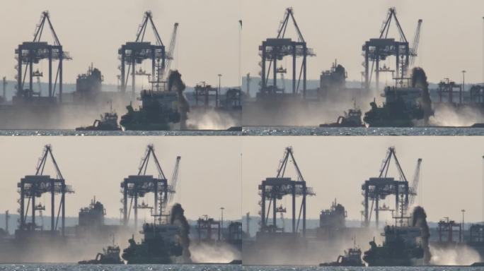 集装箱码头附近的船舶用高压水枪喷水