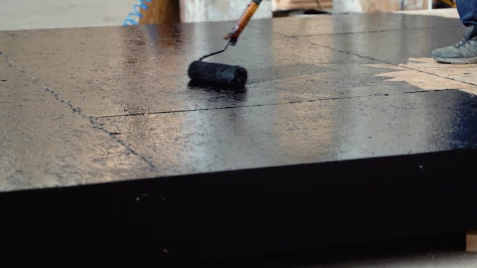 涂热树脂在地板上防水，涂树脂的滚筒和桶，涂黑色和液体树脂。模块化预制房屋概念