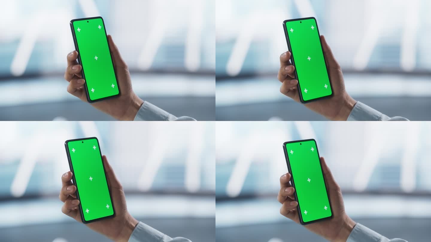 商人手持智能手机，看着绿色的Chromakey模拟显示屏。视频模板与运动跟踪器的数字营销，网站设计演