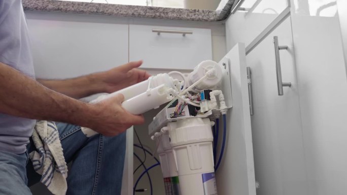 西班牙高级水管工清洗家庭反渗透过滤器进行维护。