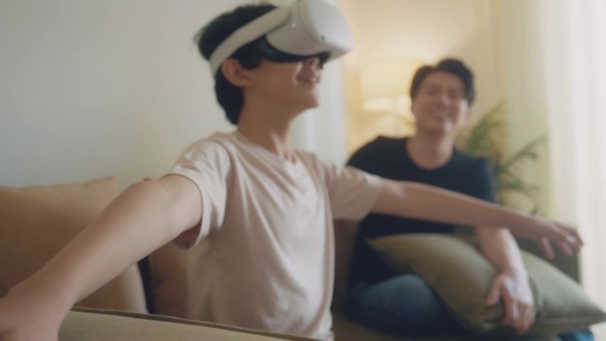 一个男孩和他的父亲在客厅里玩着虚拟现实耳机，兴奋得像飞一样。