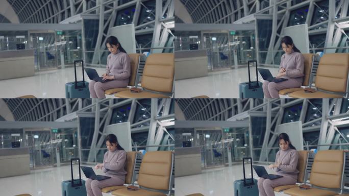 一个穿紫色衣服的女人拎着行李箱独自坐着，她用笔记本电脑工作，在登机前查看时间