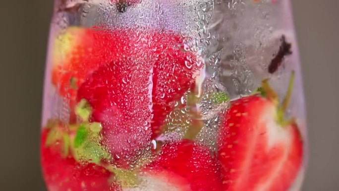 将冰冻草莓夏季鸡尾酒与冰和朗姆酒混合，慢镜头特写