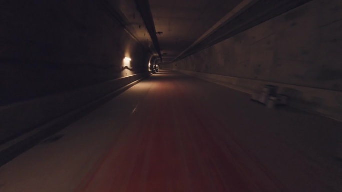 无人机飞行第一人称POV飞行通过一个黑暗的隧道与道路时间延迟