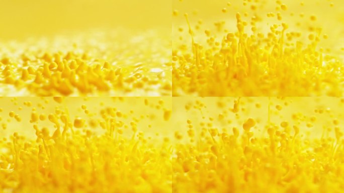黄色油漆溅在慢动作-抽象大力不断弹跳流体使液滴和飞溅