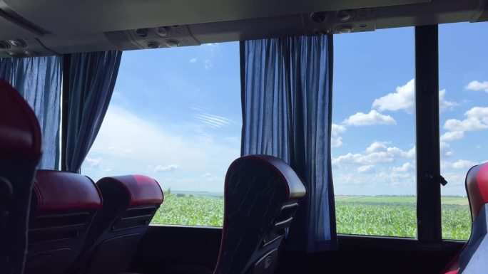 视频中公交车内的田野蓝天白云闪烁窗外空座位舒适的公共交通