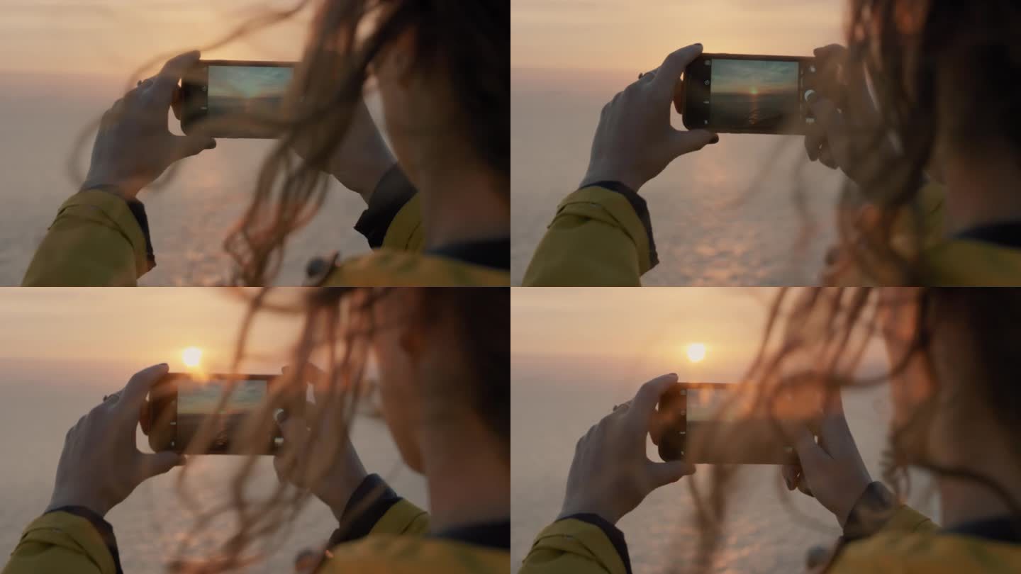 用智能手机拍摄日落的女人女孩拍照，头发吹过海景，柔和的光线镜头光晕景观自然背景，享受假期旅行冒险