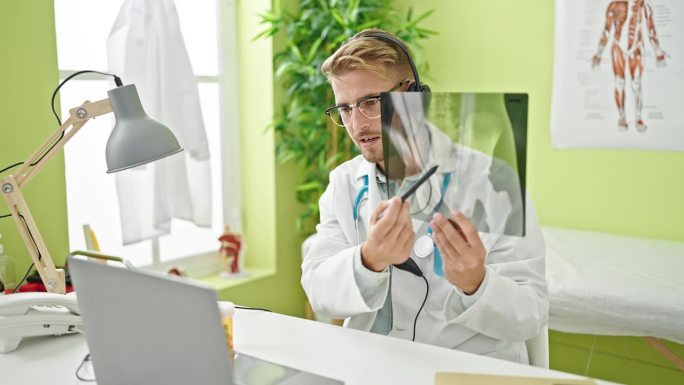年轻的白人男性医生在网上预约，在诊所显示x光片
