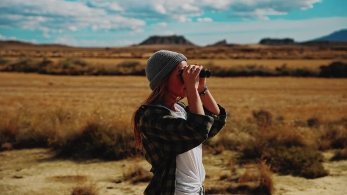 一名妇女用双筒望远镜在摩洛哥沙漠中寻找方向