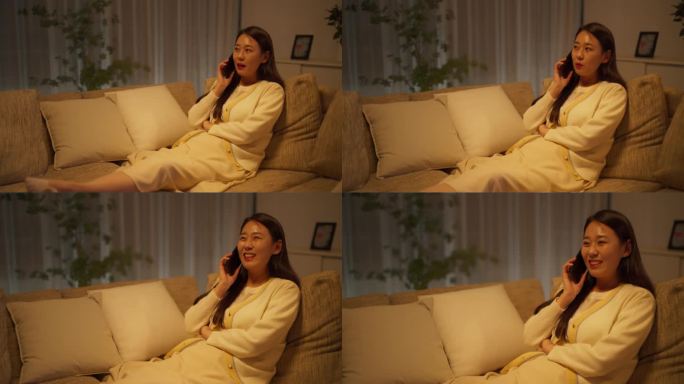 年轻的韩国女子在晚上打电话给朋友。美丽的亚洲女性舒适地坐在舒适公寓的沙发上，与朋友和家人讨论未来的旅