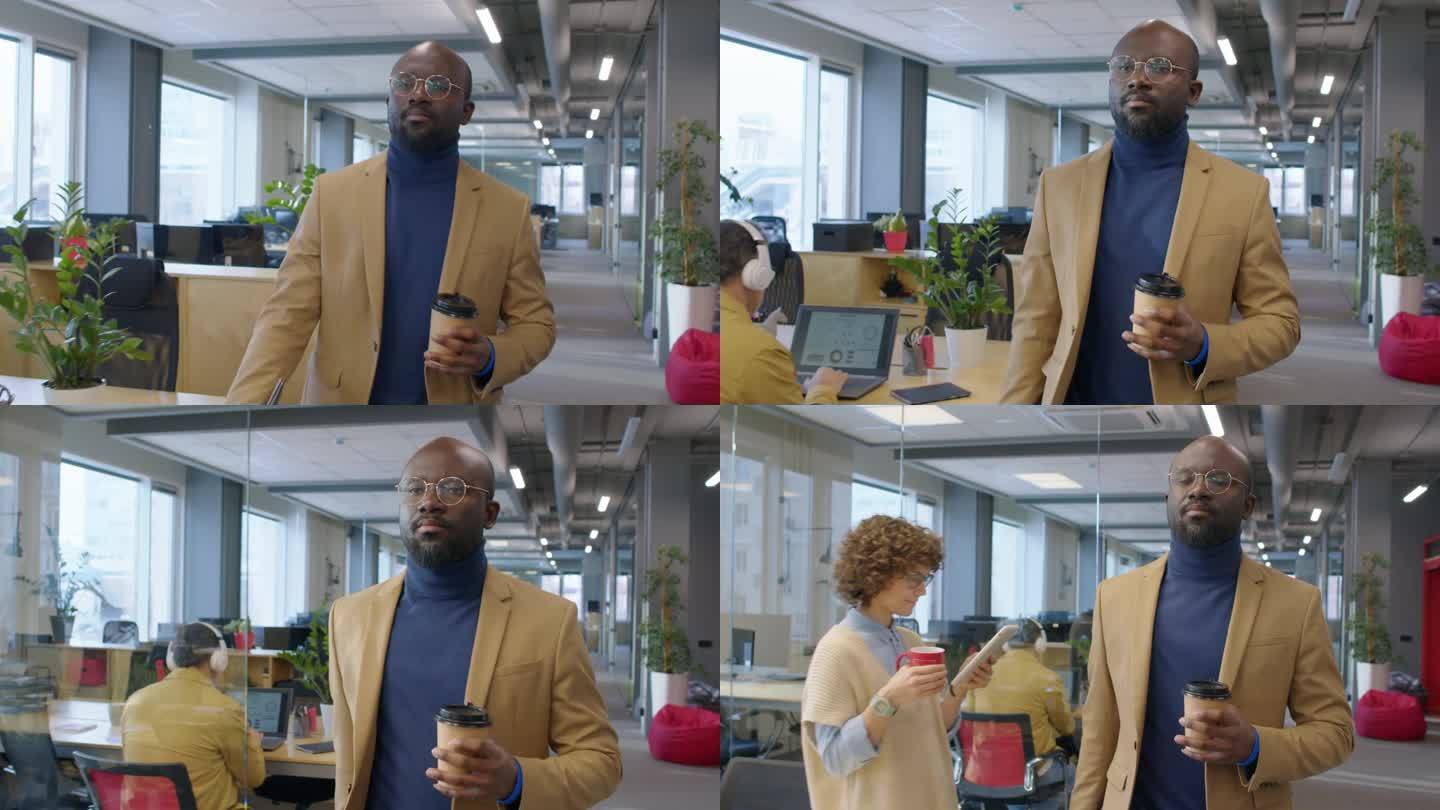 非裔美国经理端着咖啡走过办公室