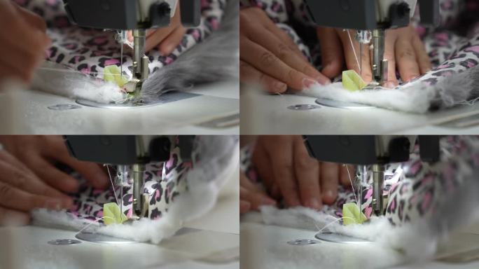 一只女工的手把布料推过缝纫机