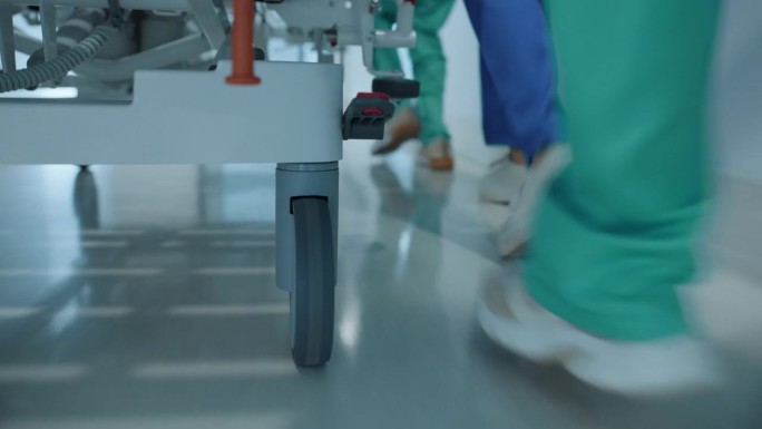 医院，医生和脚在紧急情况下与床在医疗保健服务，支持或帮助医疗创伤。护理团队，赶快推着轮床走到手术室、