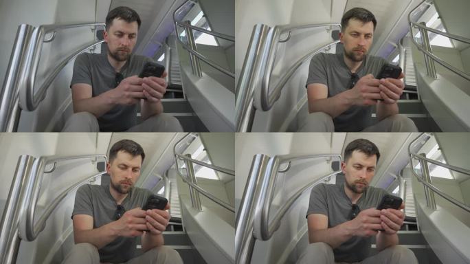 年轻人乘坐双层火车，坐在飞机上玩智能手机。火车旅行期间没有座位。男性乘坐双层火车上下班，坐在飞机上上