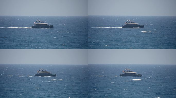 一艘摩托化的双体船在浩瀚的大海上巡游，在它的身后留下一串翻腾的波浪。
