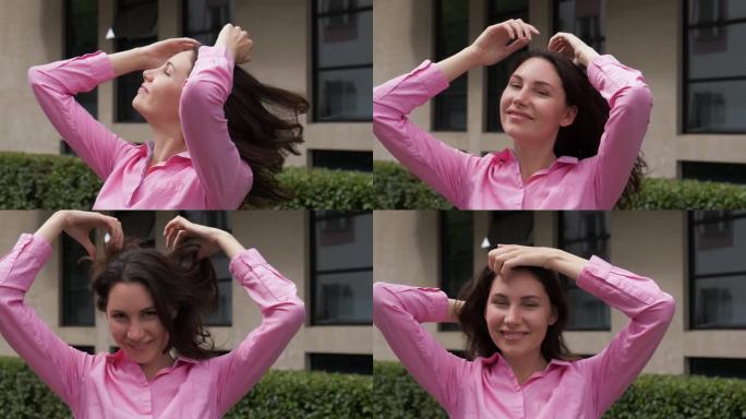 一个年轻漂亮的女人抚摸着她的发型，摇晃着她的头发。自由，粗心，快乐