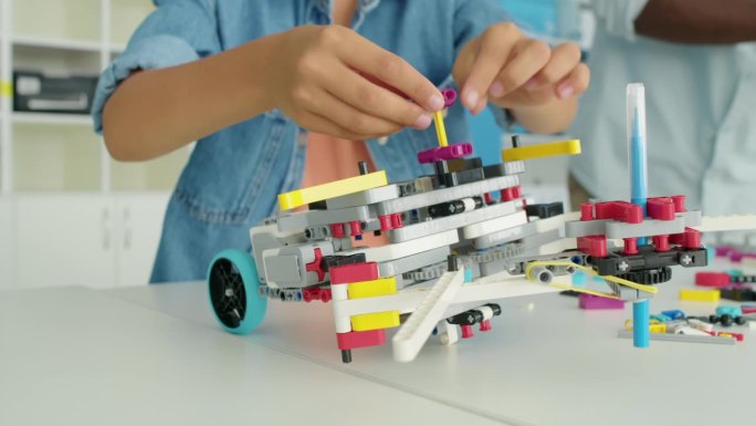 匿名儿童的手从玩具塑料块构建结构