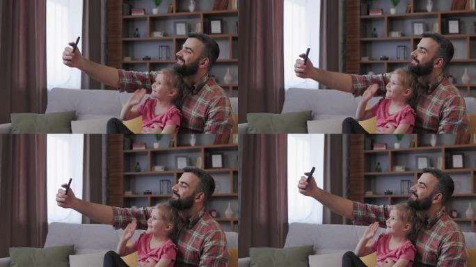 阖家欢乐。年轻的父亲和可爱的女儿在智能手机上玩自拍。爸爸带着小女儿尽情地共度时光，在家休闲。父亲节。