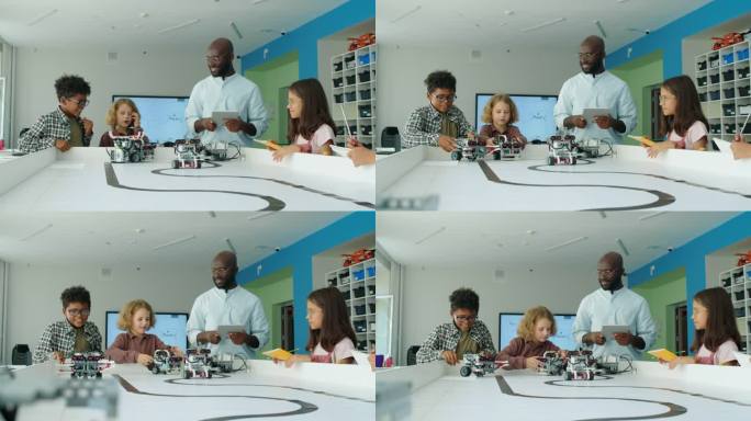 兴奋的孩子和老师看着电动机器人移动和战斗