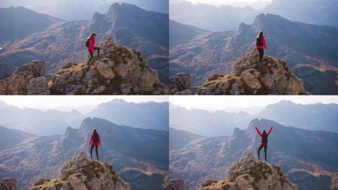 征服攀登的女人，站在山峰上伸开双臂