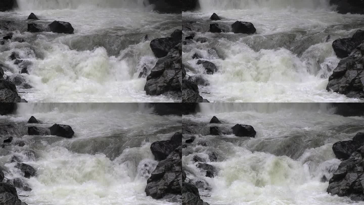 瀑布后的慢动作，有泡沫的河水在狭窄的岩石和多石的山谷中流动