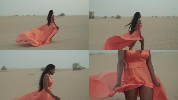 黑发的年轻女子赤脚走在沙漠的沙滩上，衣服在风中飘动