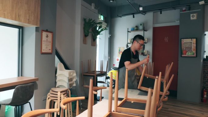 一位亚洲男性餐厅老板在开业前精心准备餐具。