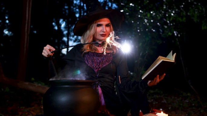 一个年轻的女巫在万圣节的仪式上用闪亮的魔杖和白烟效果在森林里施咒。