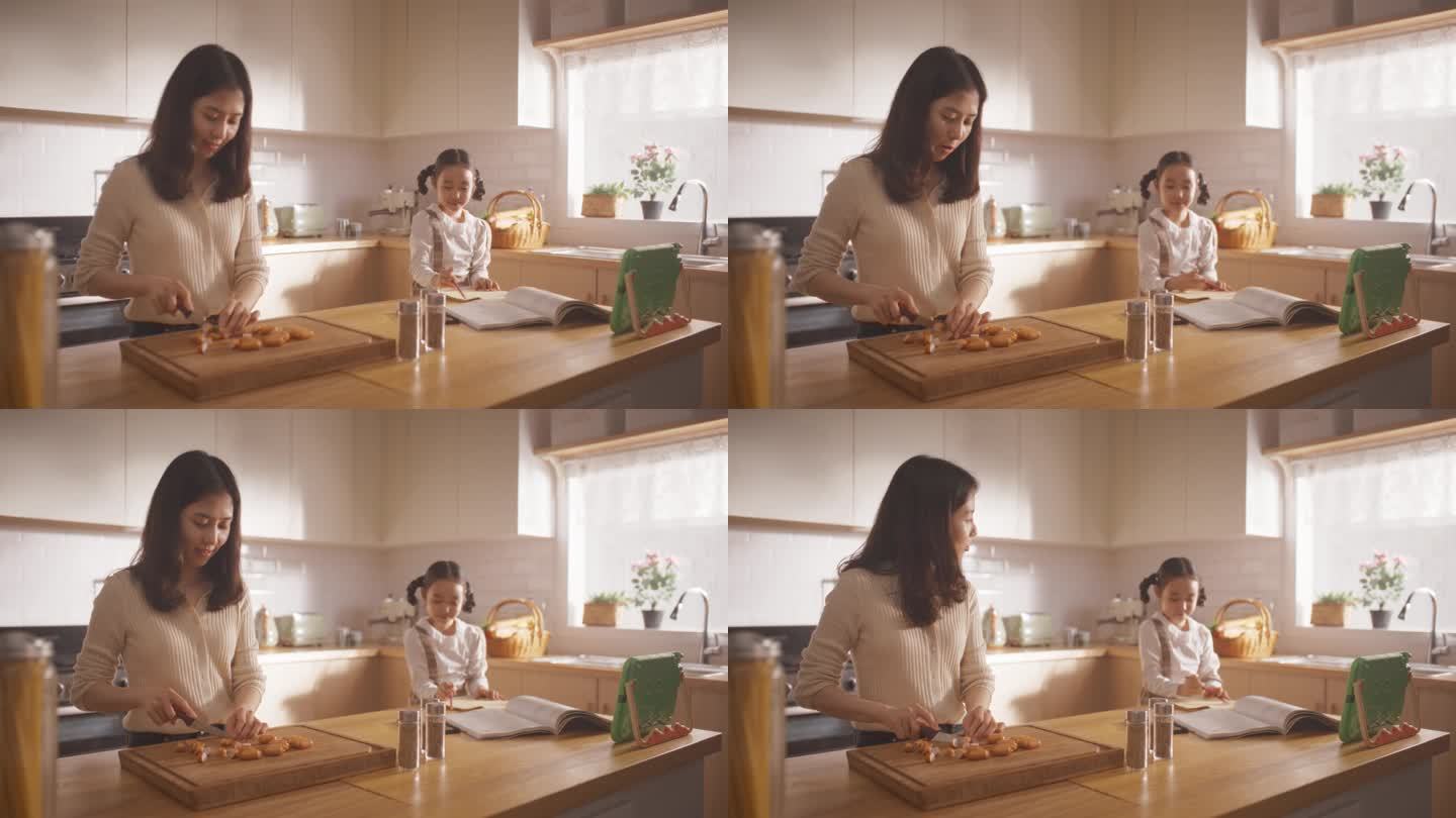 一个韩国女人和她的女儿在家里的厨房里的肖像:美丽的母亲准备做午餐，同时与她旁边的可爱的孩子交谈。幸福