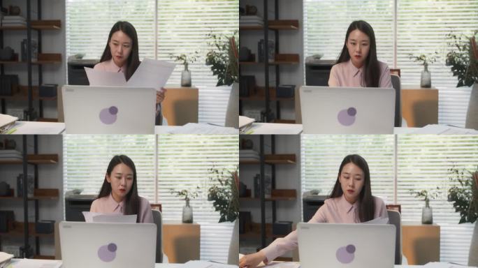 迷人的金融专家忙于分析利润，成本和收入报告在笔记本电脑上。年轻时尚的韩国专家坐在现代办公场所的办公桌