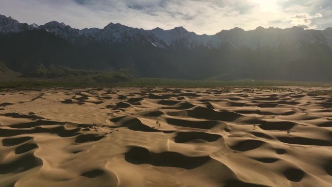 从巴基斯坦北部斯卡都的喀喇昆仑山脉拍摄的被雪帽山包围的卡特帕纳寒冷沙漠的无人机日落视图