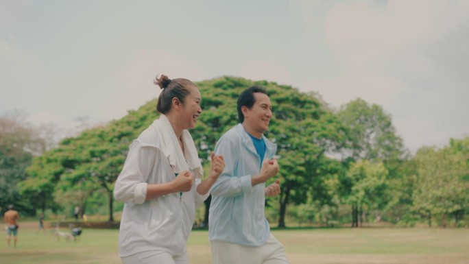 致力于运动的亚洲运动员:成熟的男人和女人通过户外跑步实现健身目标。