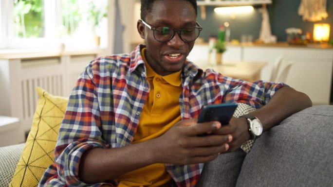 年轻的非洲裔美国人在家使用手机