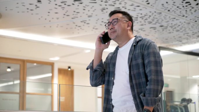 一位沉着的中亚企业家正在接听电话，在处理重要的商业事务时，流露出自信和专注
